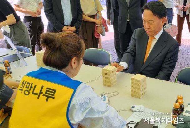 이성헌 서대문구청장이 17일 연세대 학생회관 앞에서 열린 장애인 인식개선 체험행사에서 ‘저주파 치료기를 팔에 장착하고 블록 쌓기’ 체험을 하고 있다.