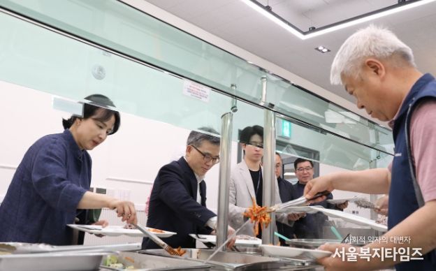 직원과 함께 배식받는 사진