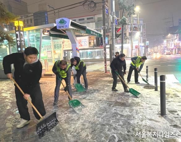 강북구 재난도우미들이 겨울철 주민들의 안전한 보행을 위해 거리에 쌓인 눈과 얼음을 치우고 있다. 