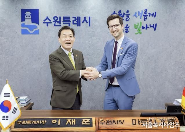 이재준 수원시장이 마르틴 호른 프라이부르크시장에게 명예 수원시장 명패를 전달한 후 활짝 웃고 있다.