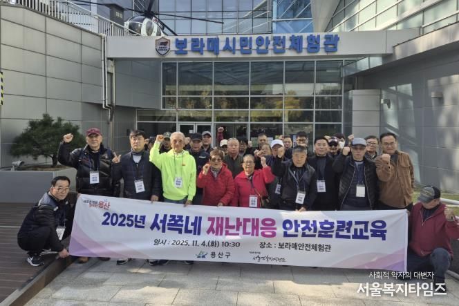 용산구가 추진한 재난대응 안전훈련에 참가한 서울역 쪽방주민들이 교육을 마치고 단체 기념촬영을 하고 있다