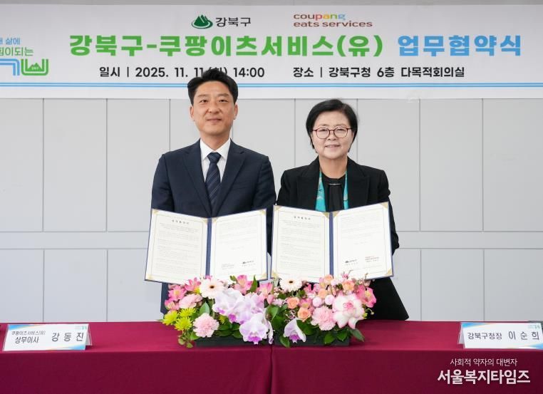 이순희 강북구청장(오른쪽)과 강동진 쿠팡이츠서비스 상무이사가 11일 강북구청 다목적회의실에서 업무협약을 체결한 뒤 협약서를 들어 보이고 있다.