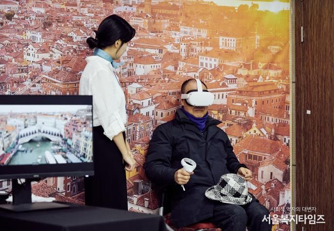 용산구가 관광약자를 위해 운영한 ‘글로벌 VR 여행 체험 프로그램’에서 한 주민이 가상 여행을 체험하고 있다.