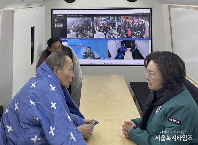 박희영 용산구청장이 재난현장지휘버스에서 임시대피 중인 청파동 화재 피해 주민들의 안전 상태를 살피고 있다.