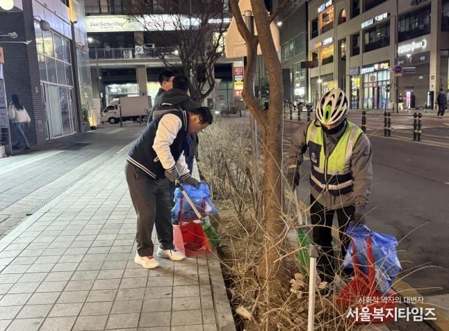 이현재 하남시장이 지난 21일 저녁 미사문화거리에서 시 소속 환경공무관들과 함께 빗자루를 들고 야간 청소 정화 활동을 펼치고 있다.